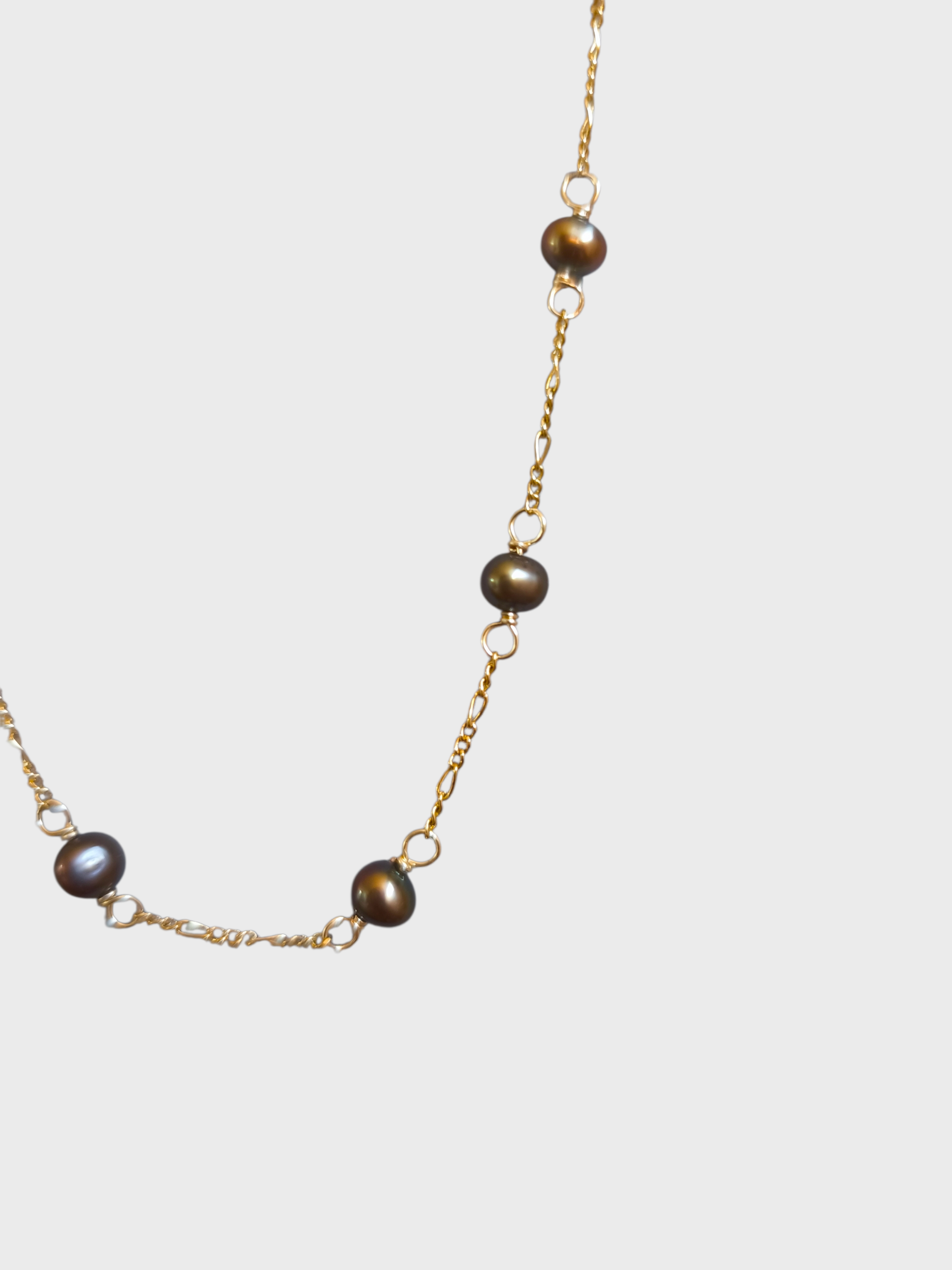Collar corto de perlas bronce.